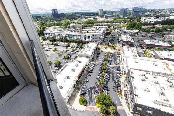 Panoramic view of a cityscape with multiple buildings and parking areas.