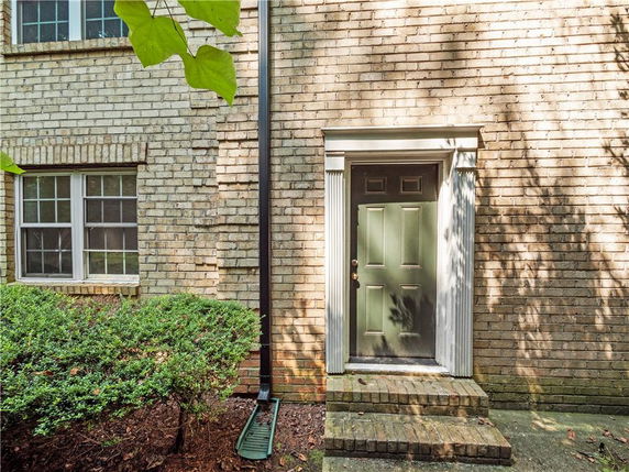 Front view of a brick building with a single door and two windows.