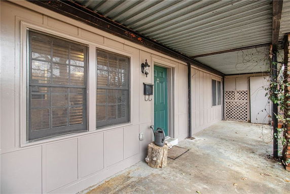 Front view of a house with a covered porch and green door.