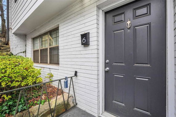 Front view of a house entrance with a dark door and a window beside it.