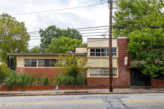 Front view of a single-story building with a brick and panel exterior.
