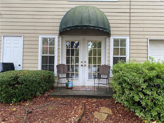 Front view of a building with a door, windows, and a green awning.