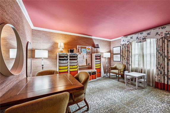 Indoor play area with tables, chairs, and storage for toys and art supplies.
