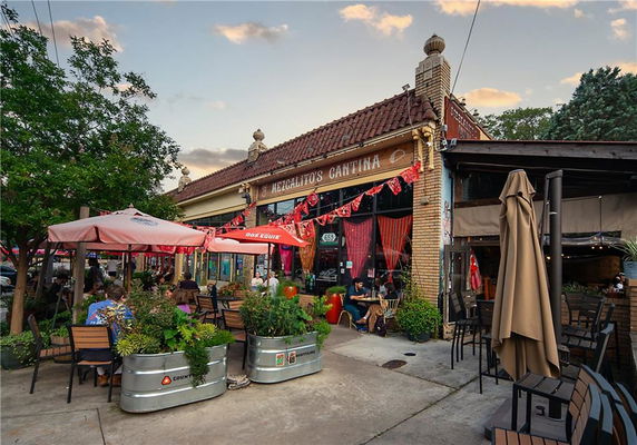 Front view of a cantina with outdoor seating and decorative umbrellas.