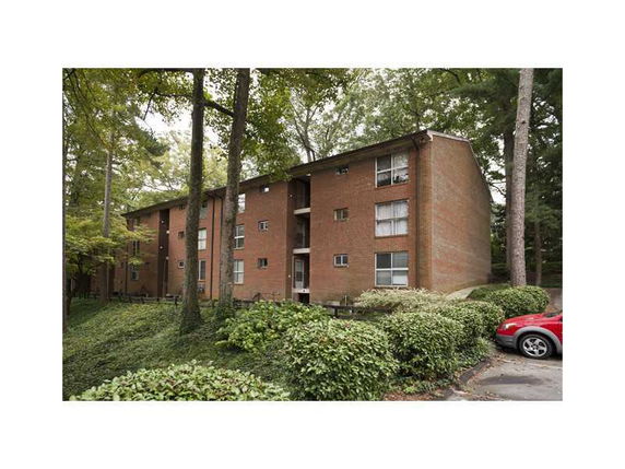 Front view of a brick apartment building with multiple floors.
