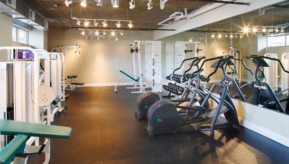 Indoor gym area with exercise equipment and mirrors.