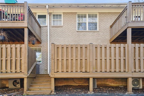 Front view of a building with wooden balconies and stairs.