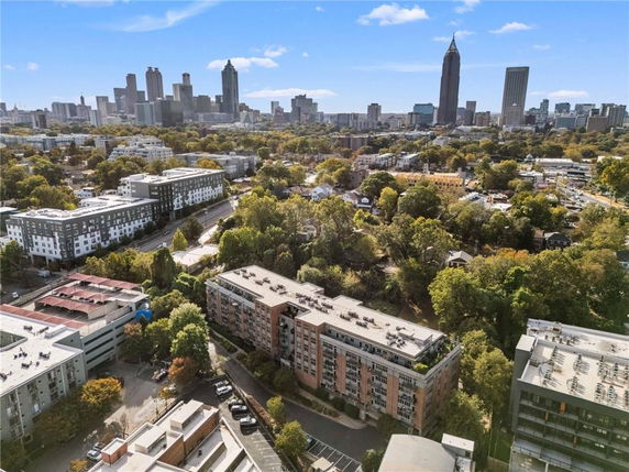 Aerial view of city buildings with a mix of high-rise and low-rise structures surrounded by trees and greenery.