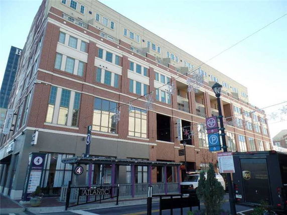 Front view of a multi-story building with a mix of brick and concrete facade.