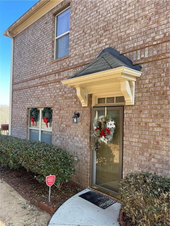 Front view of a brick house with a decorated entrance door.