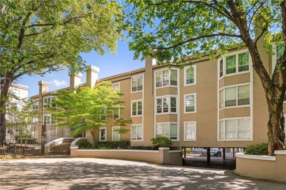 Front view of a multi-story apartment building with large windows.