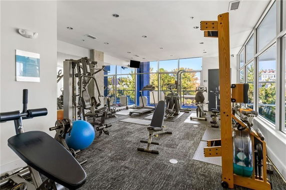 Indoor gym area with exercise equipment and large windows.