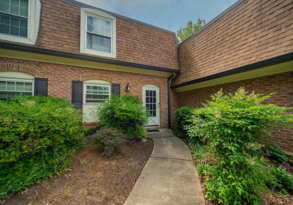 Front view of a two-story house with brick exterior and landscaped path.