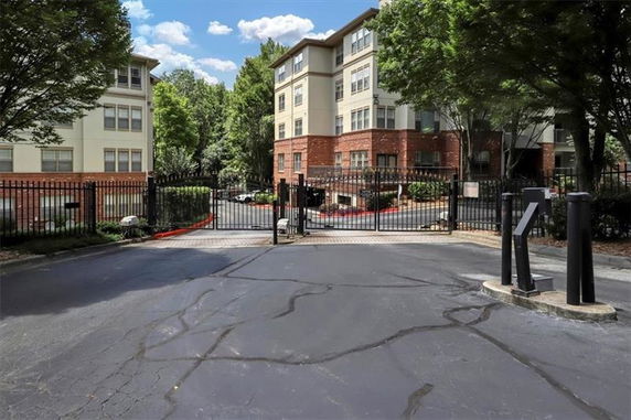 Front view of a multi-story apartment building with gated entrance.