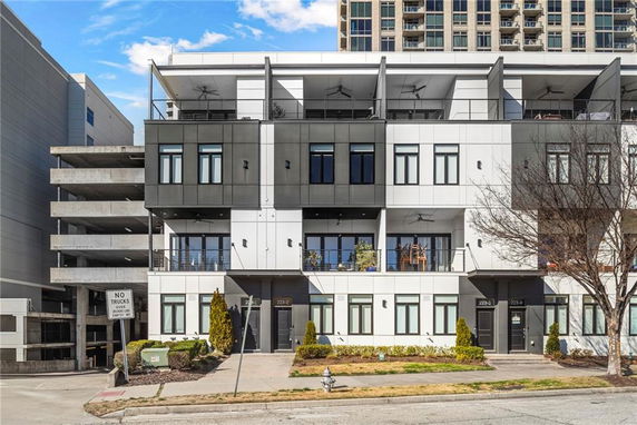 Front view of a modern multi-story building with balconies.