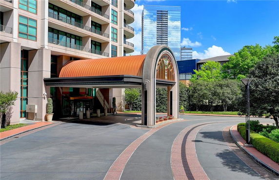 Front view of a multi-story building with a covered entrance and a circular driveway.