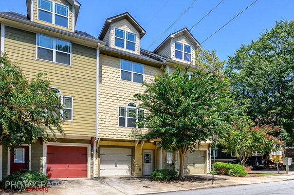 Front view of a multi-story townhouse with garages.