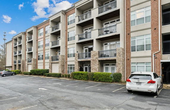 Front view of a multi-story apartment building with balconies.