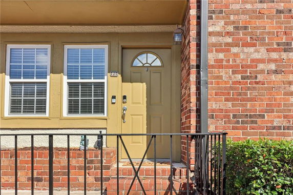 Front view of a house with brick facade and a yellow door.