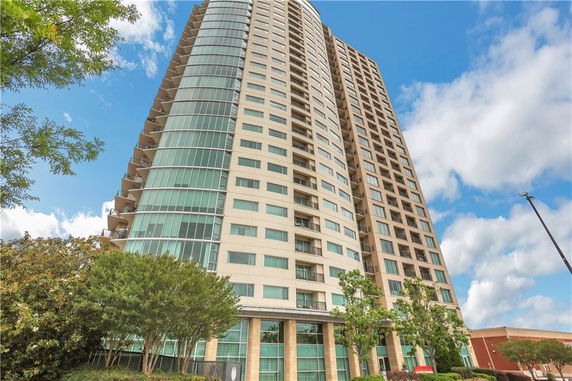 Front view of a high-rise residential building with large windows and balconies.