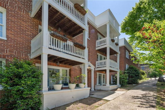 Front view of a multi-story brick building with balconies.