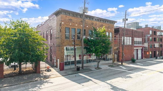 Front view of a two-story brick commercial building with large windows.