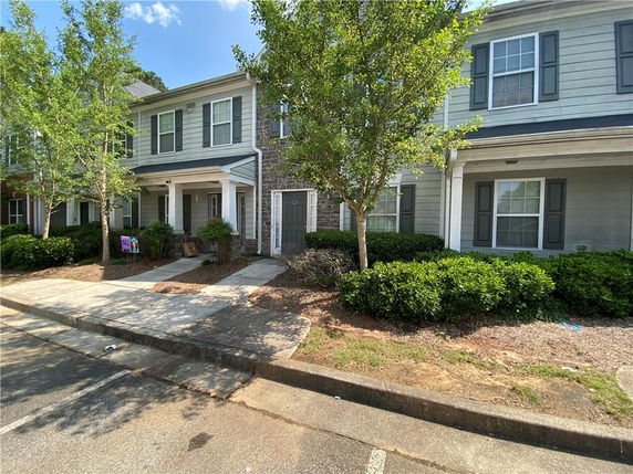 Front view of a two-story townhouse with stone and siding exterior.