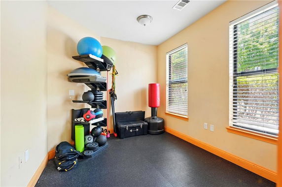 Indoor room equipped with exercise equipment and a punching bag.