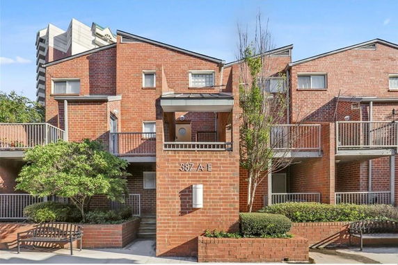 Front view of a two-story brick building with balconies.