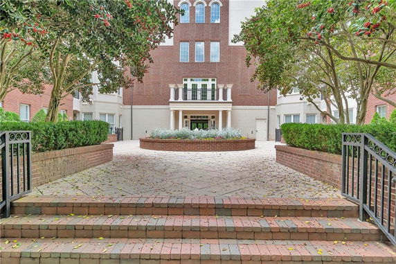Front view of a multi-story building with a brick facade and landscaped entrance.