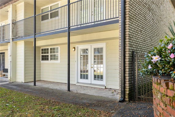 Front view of a building with a balcony and patio doors.