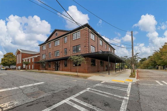 Front view of a three-story brick building with a covered entrance.