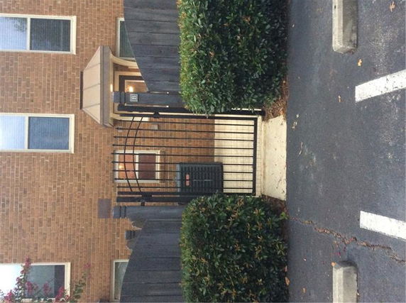 Front view of a brick building with a gated entrance.