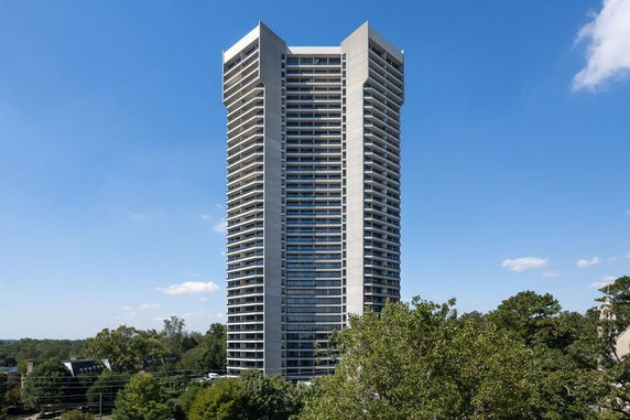 Front view of a tall, modern residential building with balconies on each floor.