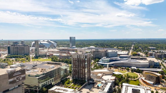 Panoramic view of a cityscape with various buildings and a stadium in the distance.