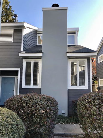 Front view of a two-story house with a chimney and blue door.