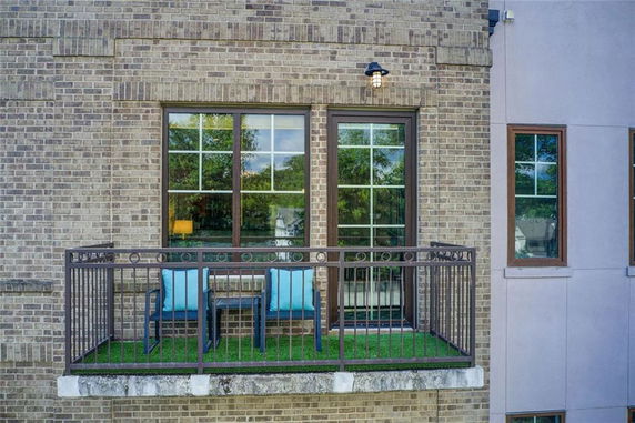 Front view of a building with a small balcony and large windows.