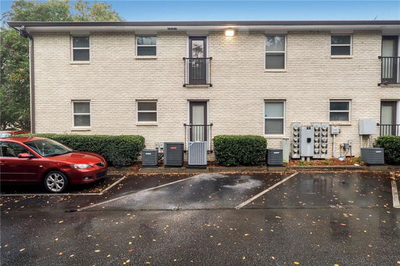 Front view of a two-story building with parking area in front.