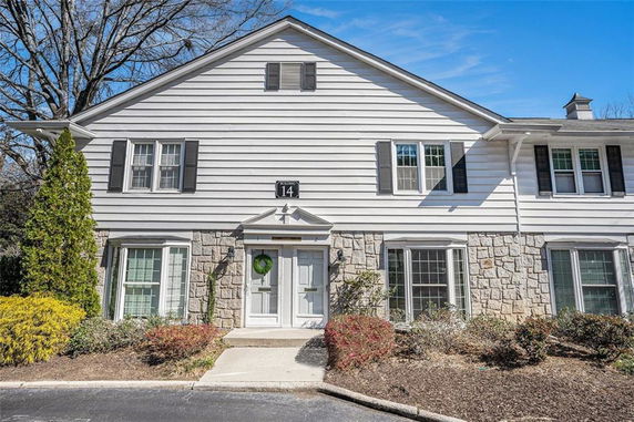 Front view of a two-story house with stone and siding exterior.