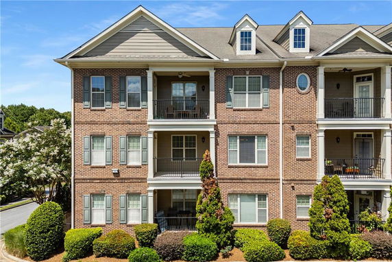 Front view of a multi-story brick building with balconies.