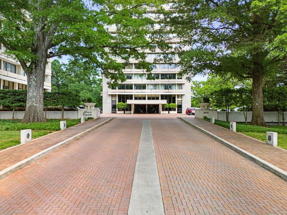 Front view of a multi-story building with a driveway leading to the entrance.