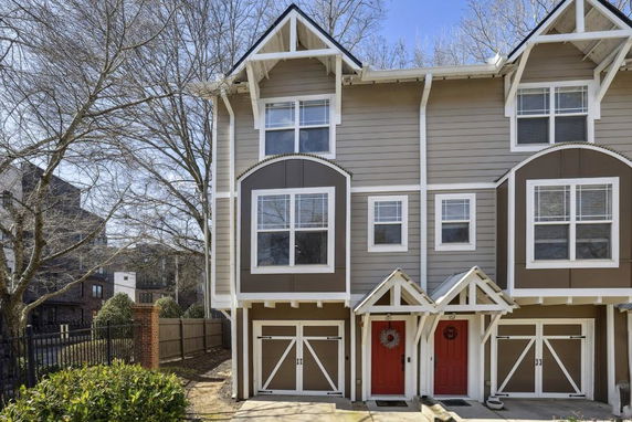 Front view of a multi-story townhouse with gabled roofs and prominent window designs.