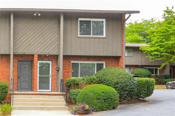 Front view of a two-story townhouse with brick and siding exterior.