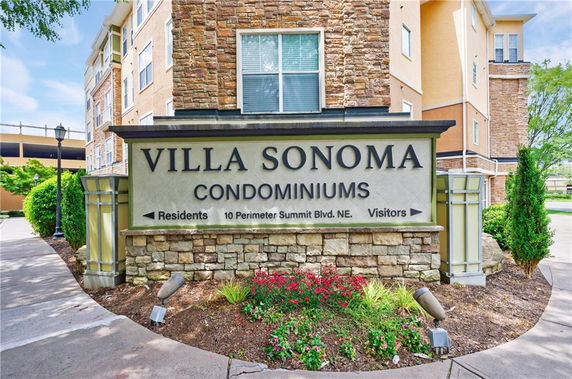 Front view of a multi-story condominium building with stone and stucco facade.