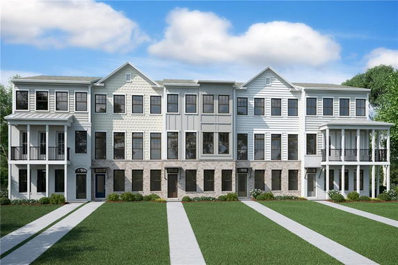 Front view of a multi-story townhouse complex with a mix of brick and siding exterior.