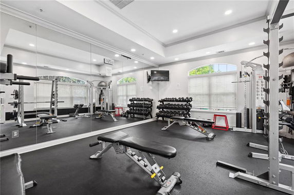 Interior view of a gym area with exercise equipment and weights.
