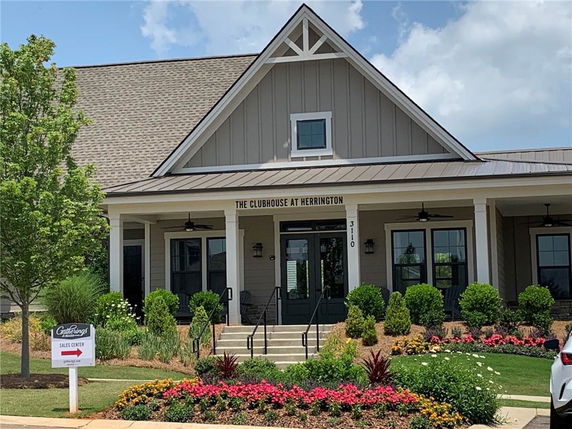 Front view of a clubhouse with a covered entry and landscaped surroundings.