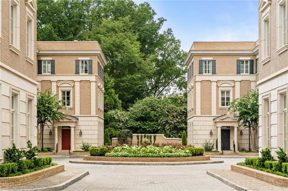 Front view of three-story buildings facing each other with a driveway in between.