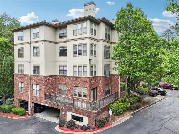 Front view of a multi-story residential building with brick and stucco exterior.