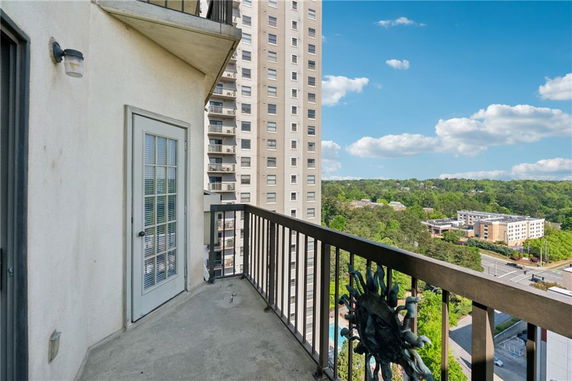 View from a balcony showing high-rise buildings and distant greenery.